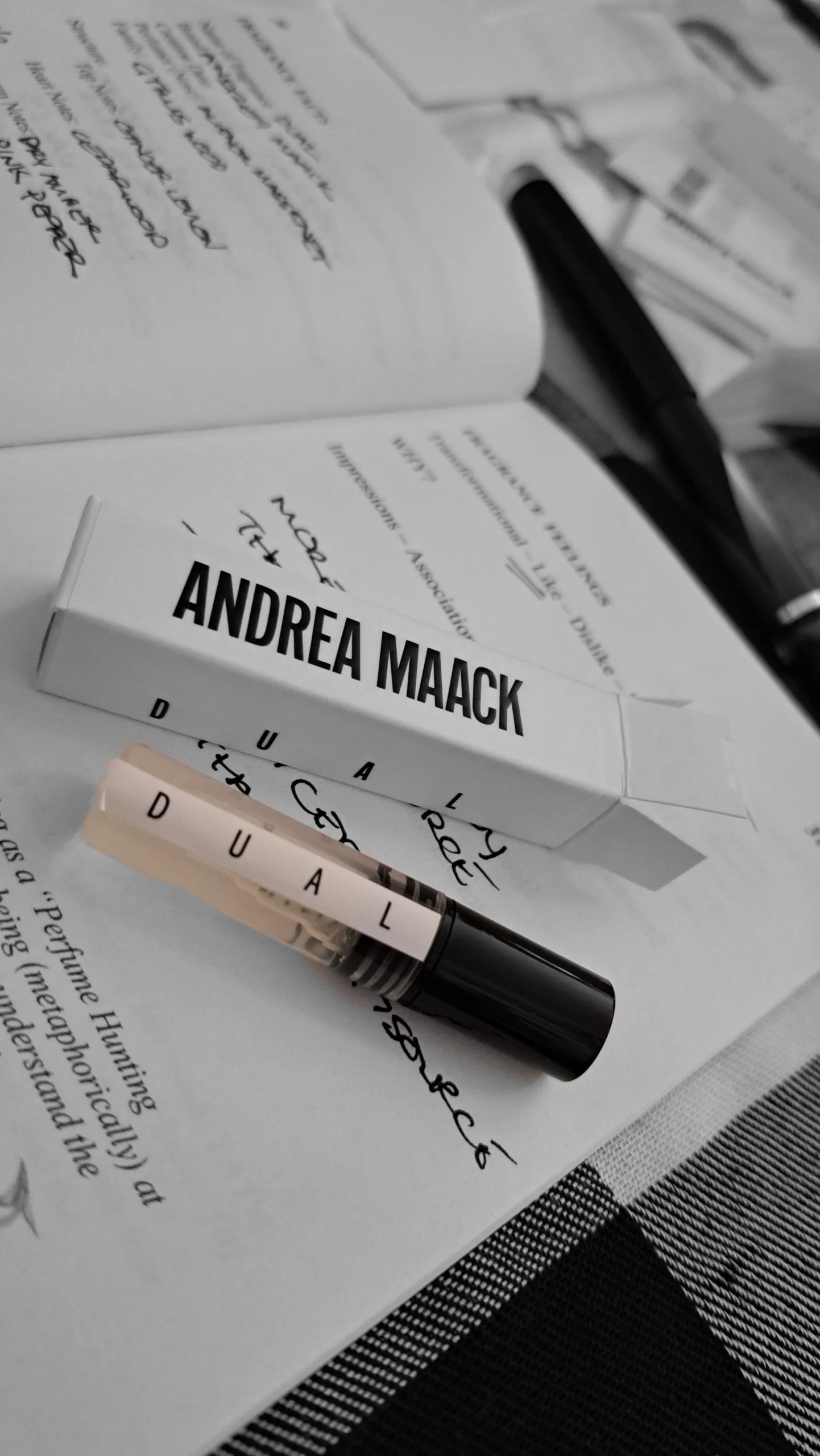 Andrea Maack Dual perfume sample and packaging on an open fragrance notebook.