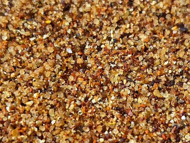 Close-up of homemade BBQ spice rub showing coarse brown sugar, paprika, and spices blended together.