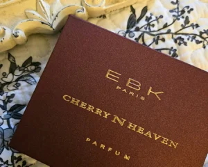 EBK Paris Cherries N Heaven parfum box photographed on patterned fabric with gold lettering